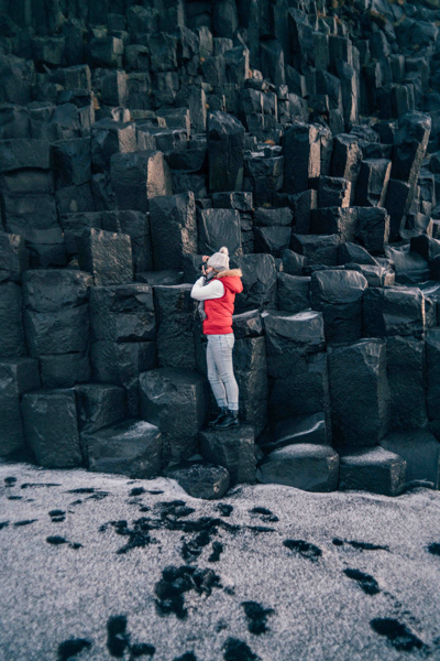 Girl standing on rocks at Reynisfjara Black Sand Beach