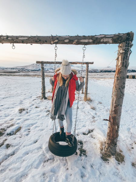Girl on tyre swing in Iceland in winter