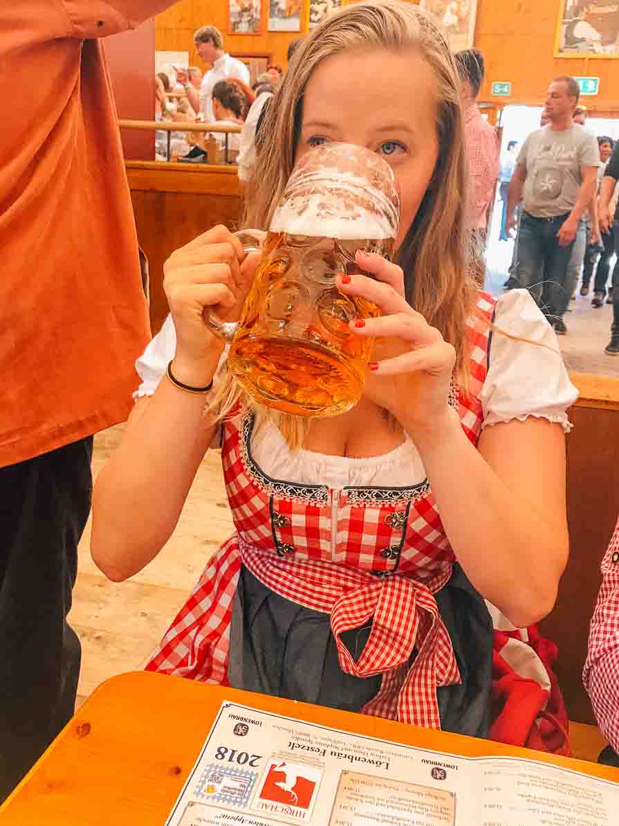 Girl in dirndl drinking beer