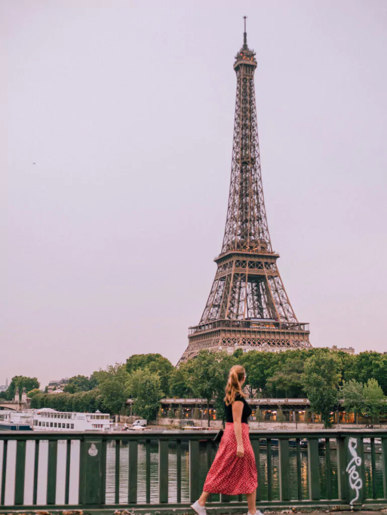 Eiffel Tower with girl walking in front