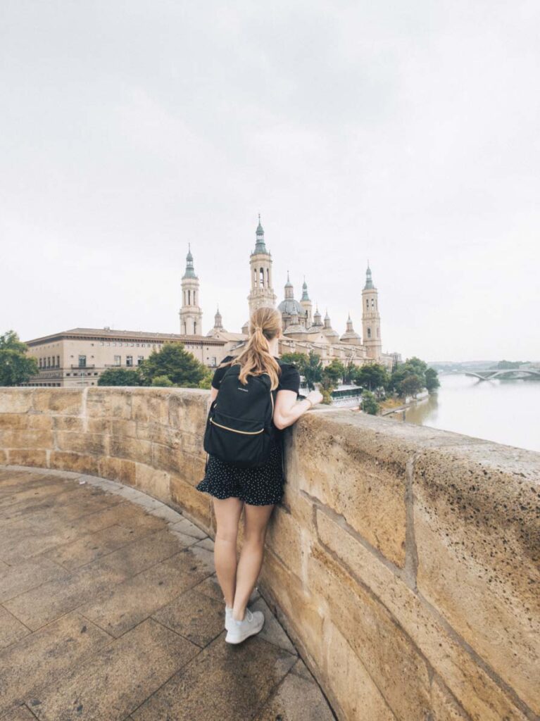 Girl standing on Stone Bridge over Ebro River in Zaragoza