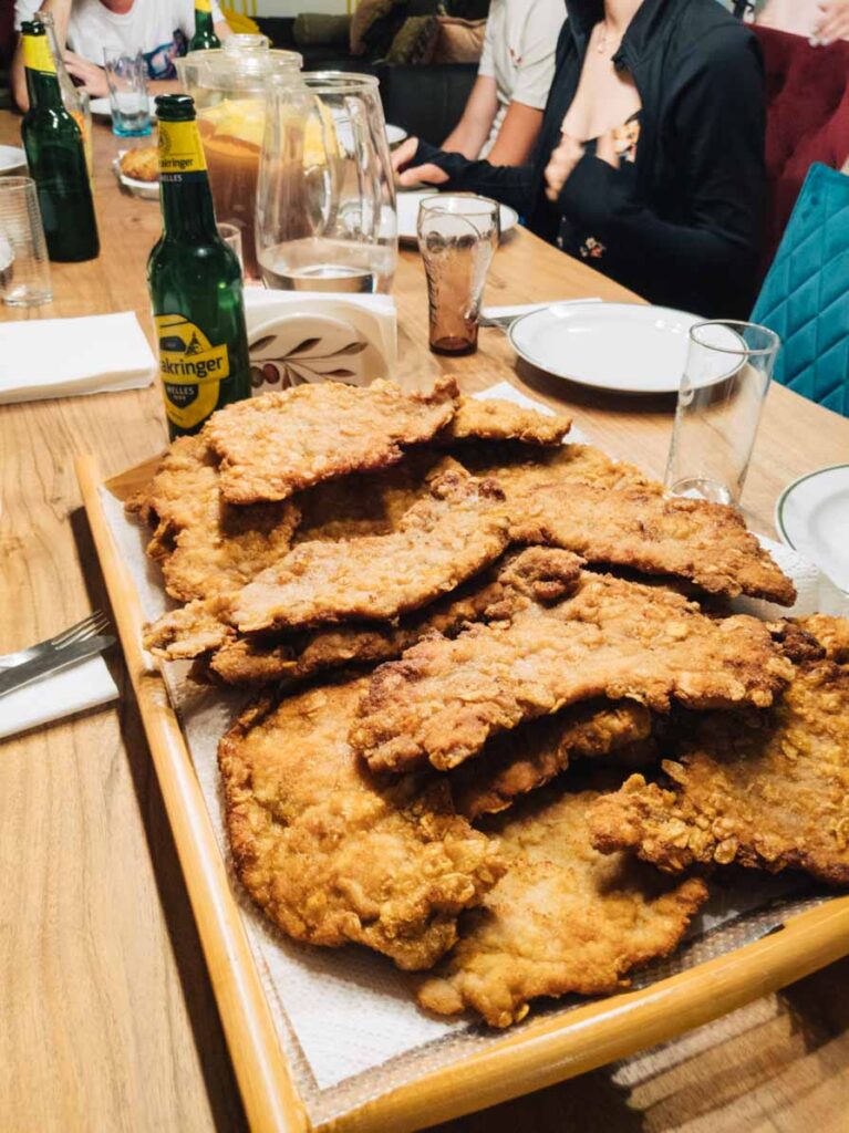 Lots of schnitzel piled on top of each other at a family dinner table