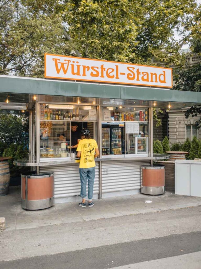 Girl standing in front of Wurstelstand in Vienna, Austria