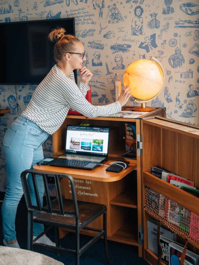 Girl spinning a globe on a desk in a Hamburg hotel room