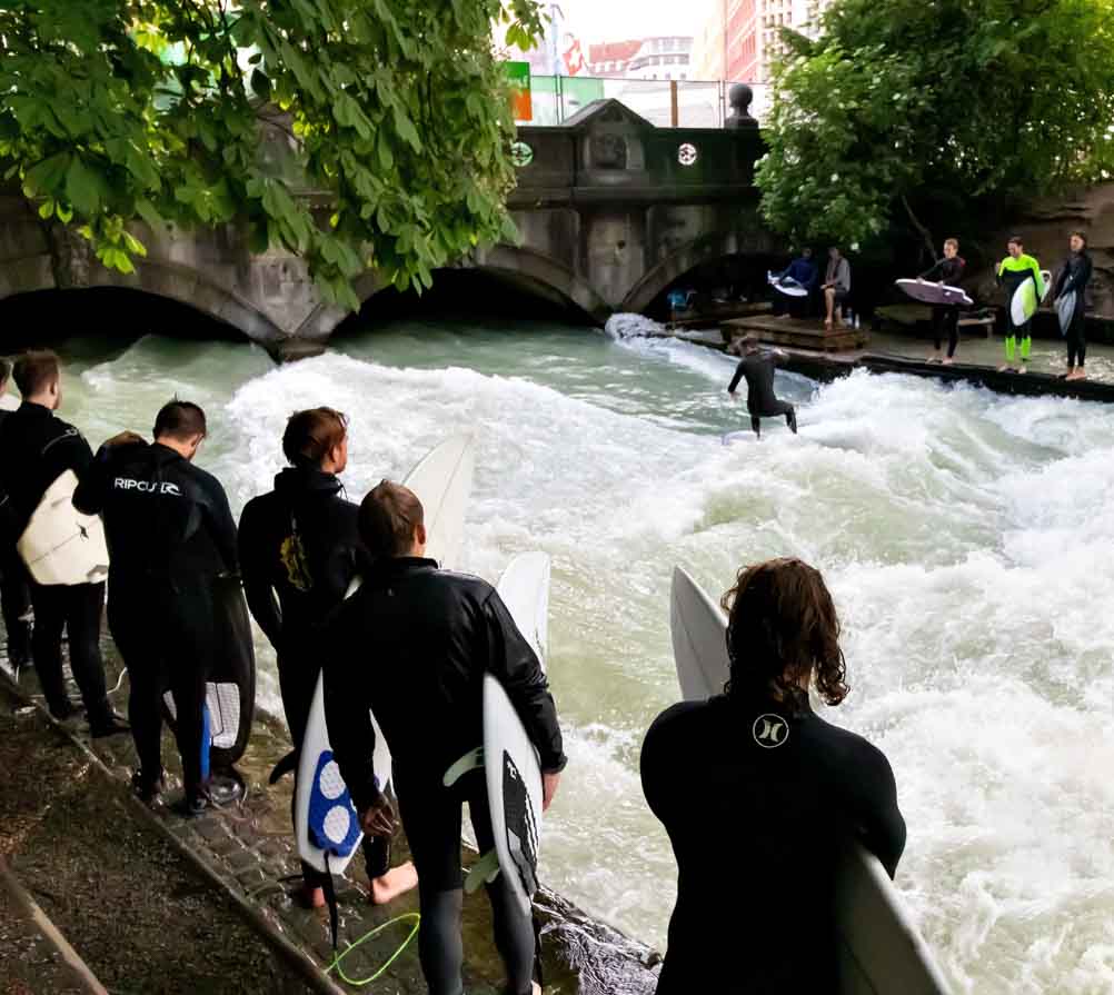 Surfers catching a wave at the Munich Eisbach surf spot