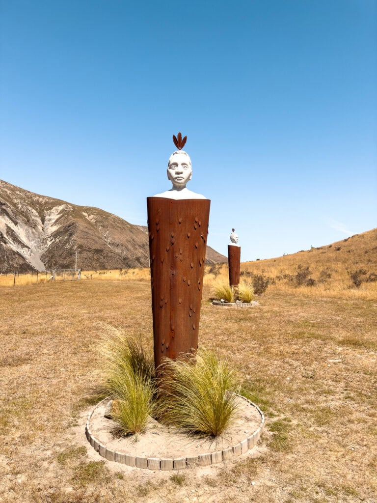 Modern Maori pou whenua art sculpture installation in a dry, tussock-covered field at Kura Tawhiti / Castle Hill near Arthur's Pass.