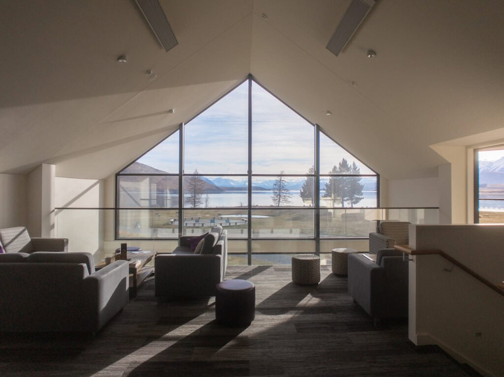 Lounge area inside Haka House Lake Tekapo hostel with large windows looking out across the lake