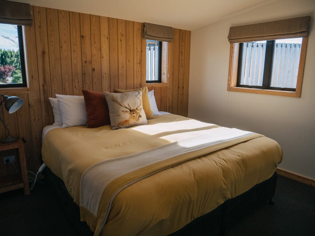 Cosy bedroom at Alpine Lodges at The Cairns in Tekapo with a double bed and timber panelled walls