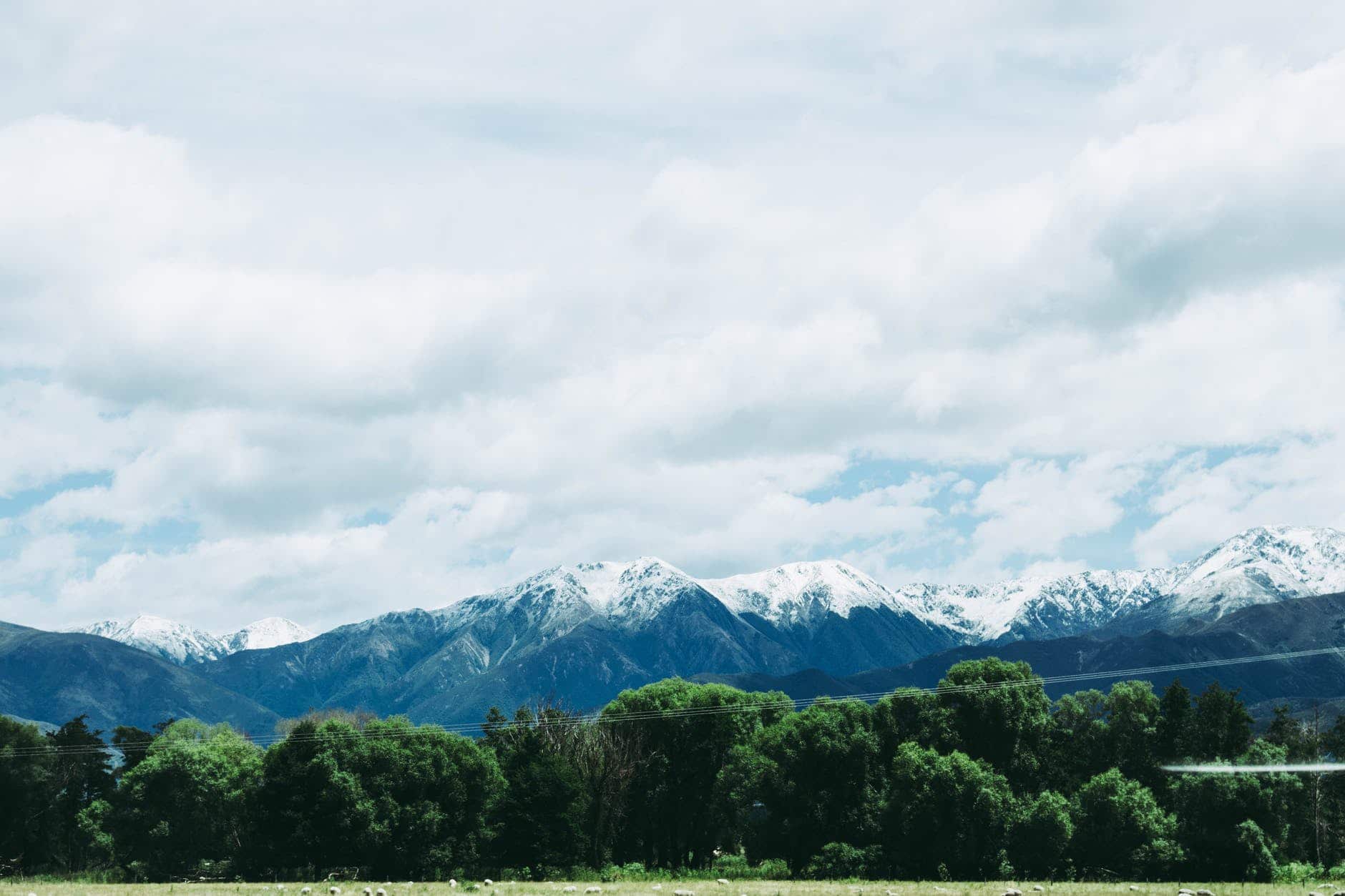 photo of mountains under cloudy sky