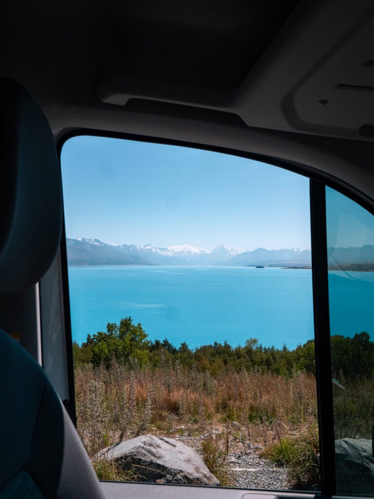 View of turquoise Lake Pukaki from the window of a campervan