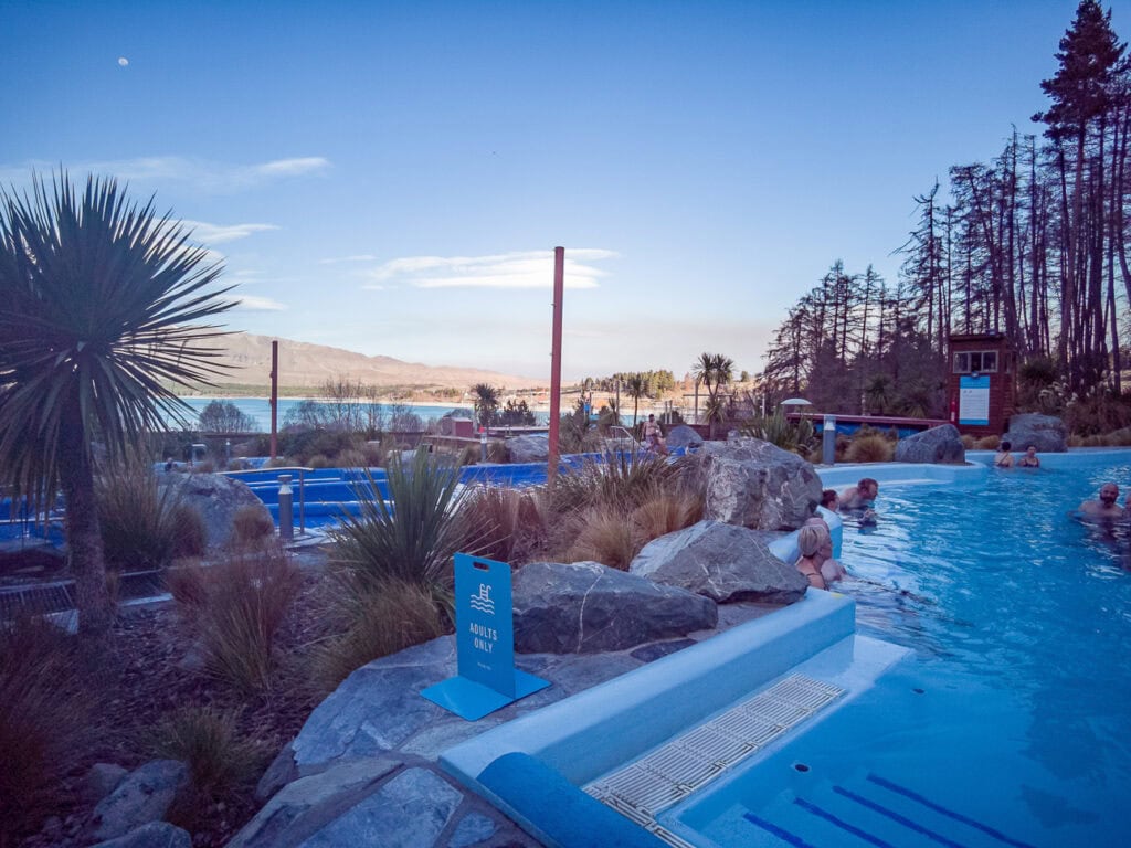 Outdoor hot pools at Tekapo Springs with a snowy mountain backdrop