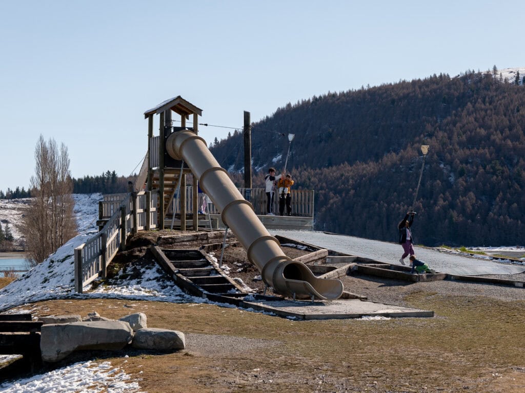 Wooden adventure playground with a long slide overlooking Lake Tekapo