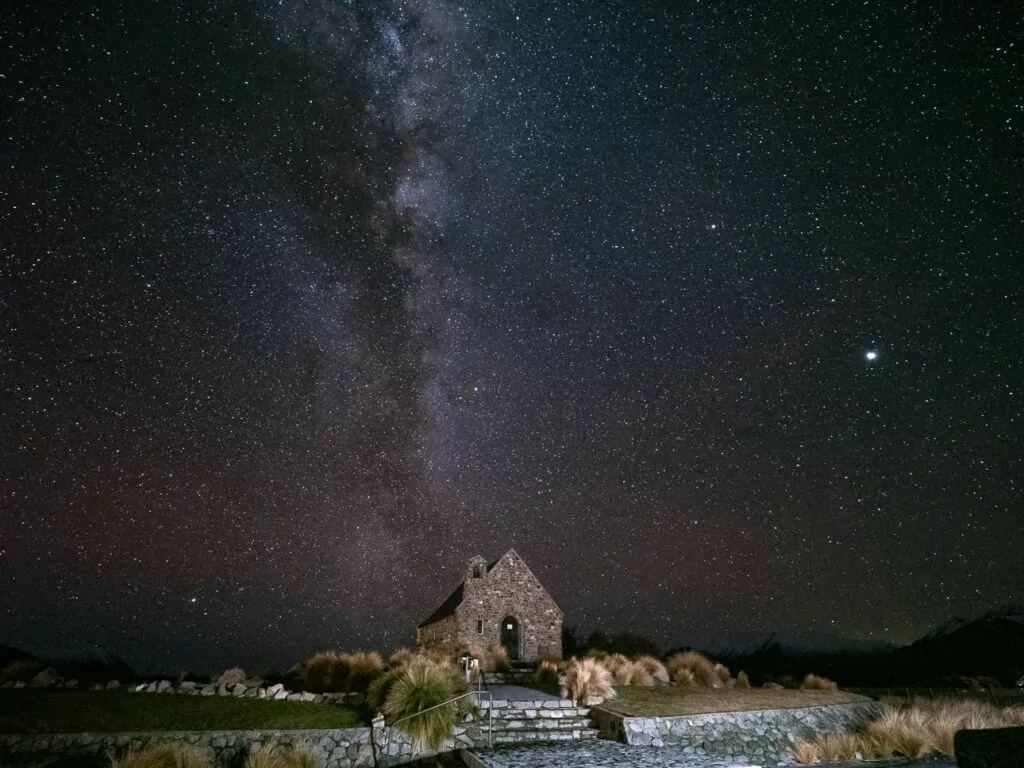 Milky Way galaxy stretching across the night sky above the historic Church of the Good Shepherd at Lake Tekapo in the Aoraki Mackenzie Dark Sky Reserve