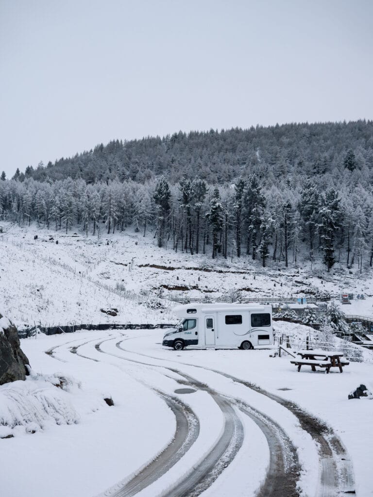 Snow-covered campsites and a campervan at Lakes Edge Holiday Park in Tekapo in winter, one of the best places to stay in Tekapo for budget travellers