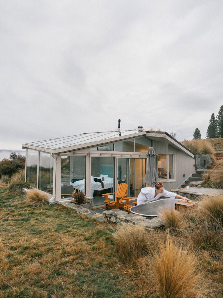 Exterior of SkyScape glass cabin in Twizel with an outdoor hot tub on the deck