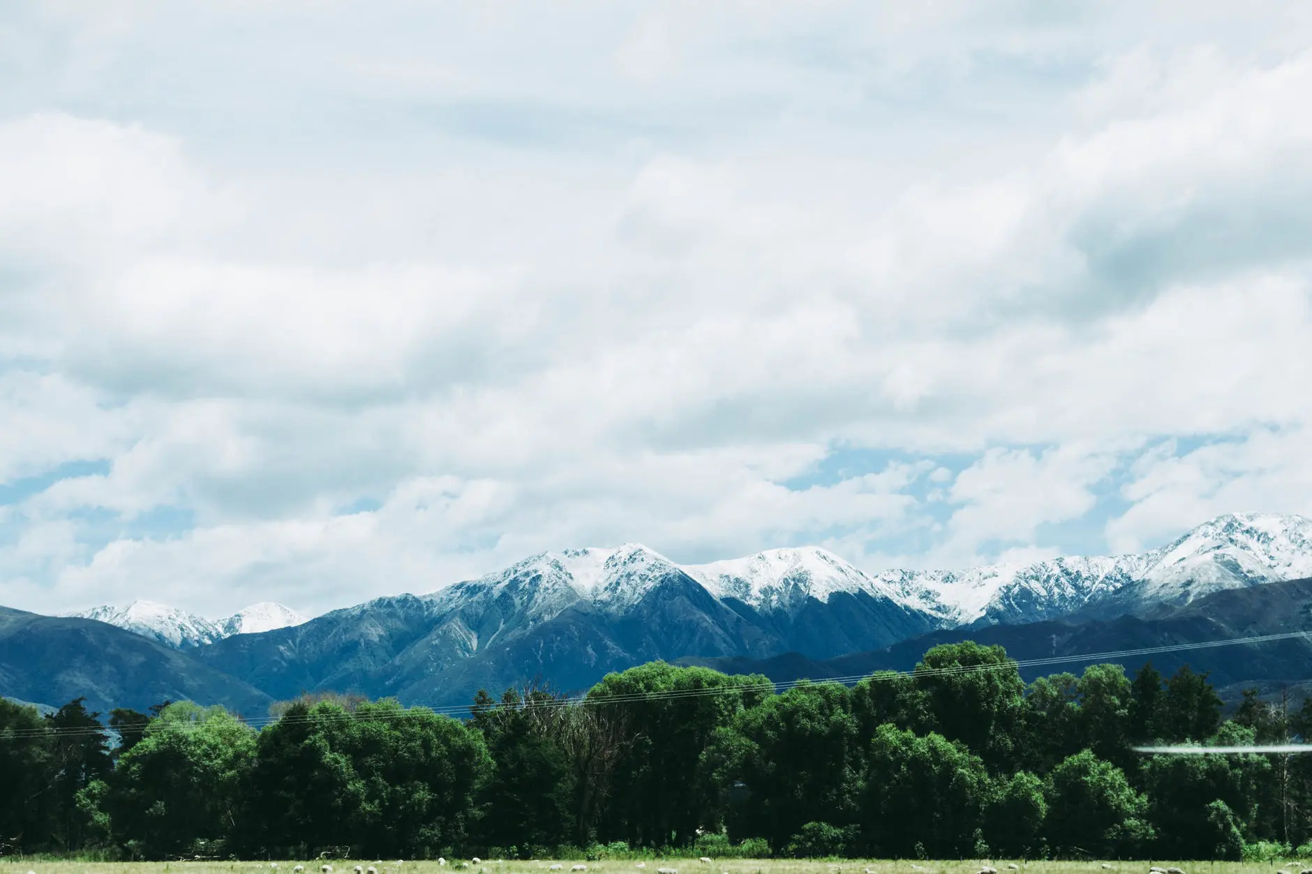 photo of mountains under cloudy sky