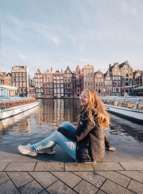 girl sitting in front of amsterdam canals