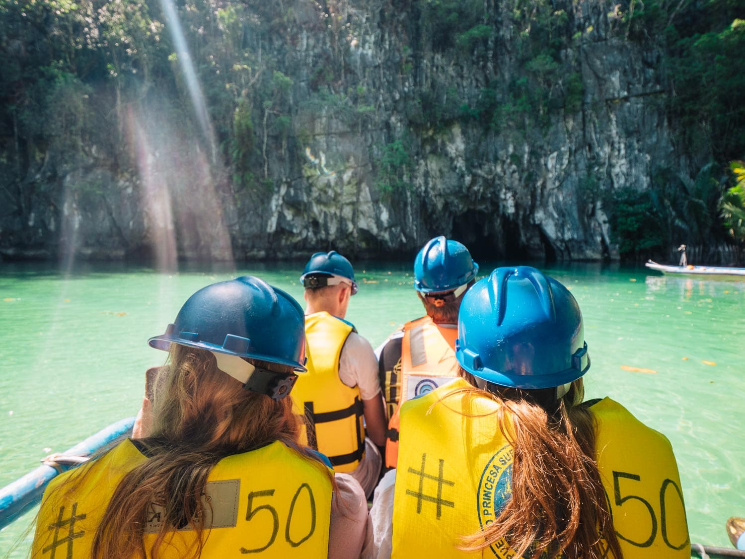 One Life Adventures group in hard hats boating into the Puerto Princesa Underground River, Palawan