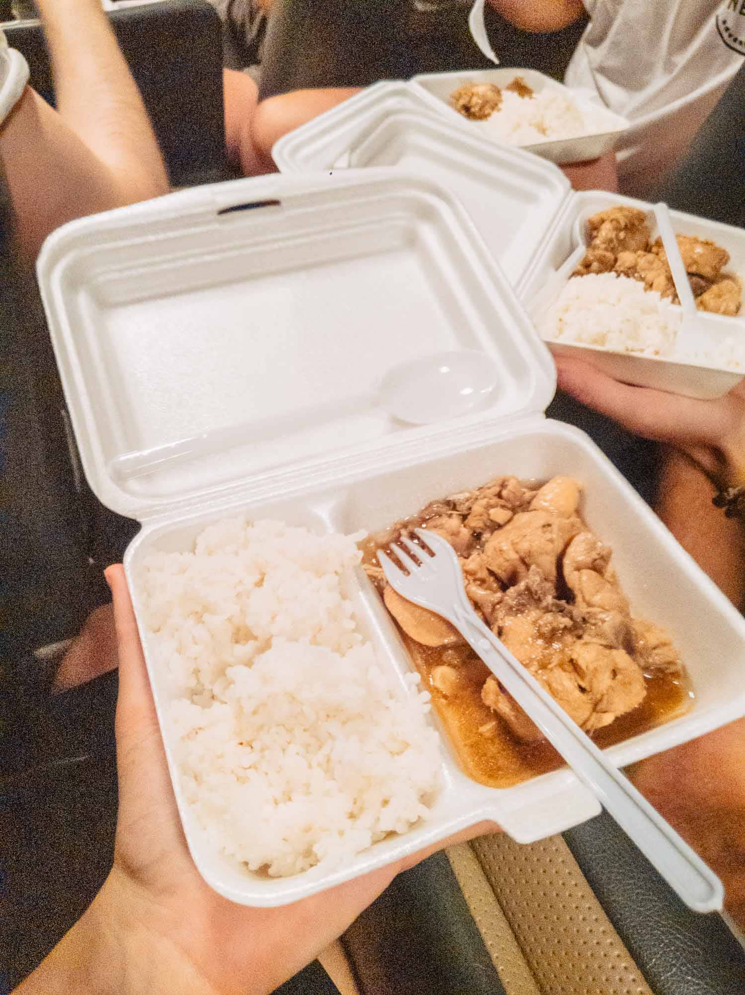 Styrofoam box of rice and chicken eaten on the bus while our Philippines tour waited for news