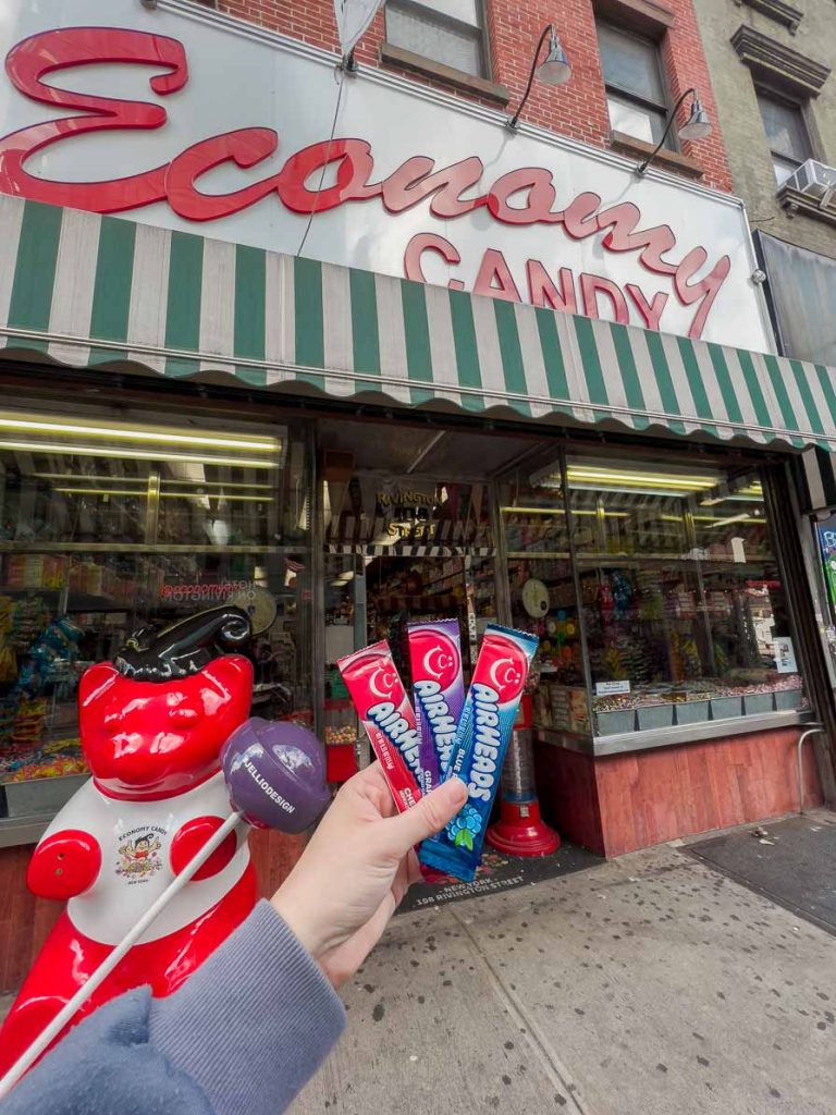 A hand holding Airheads lollies in front of economy candy in new york city