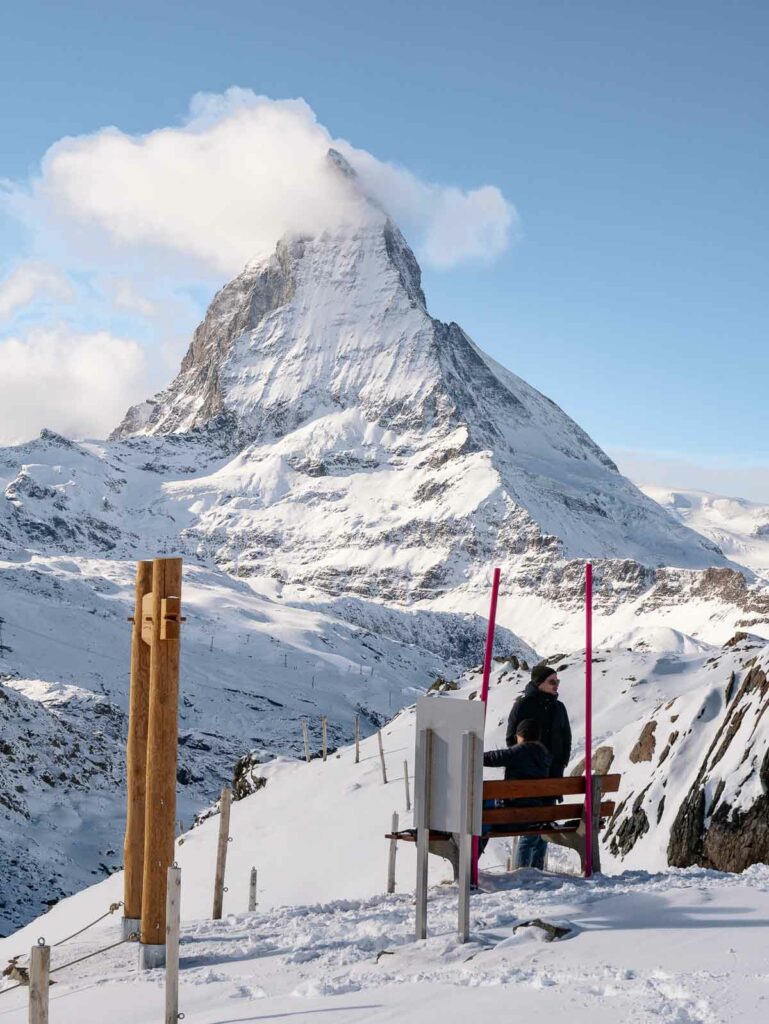 A traveler sits on a bench at Rotenboden station with the iconic Matterhorn mountain in the background, a perfect addition to a 10 day Switzerland itinerary