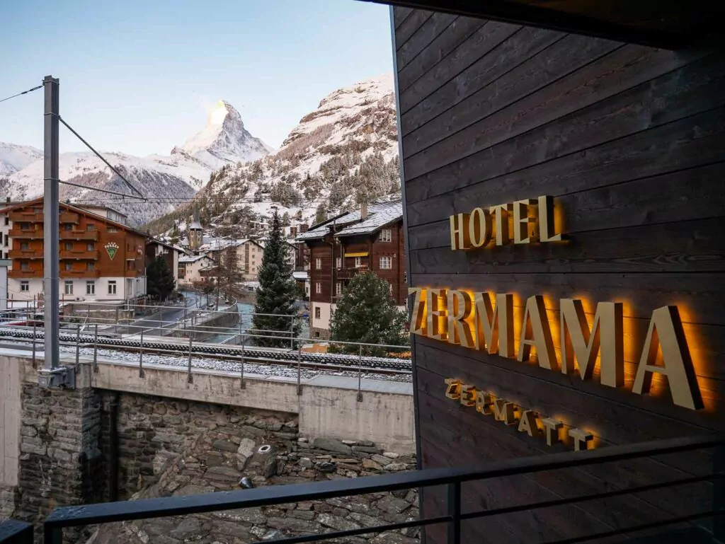The iconic Matterhorn mountain looms in the background, viewed from the balcony of Hotel Zermama, highlighting a potential scenic stay for travelers with a Swiss Travel Pass