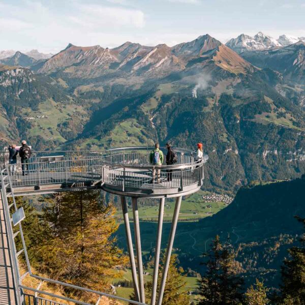 Visitors on the Stanserhorn's summit viewing platform overlook a stunning panorama of the Swiss Alps, an immersive experience in the heart of nature