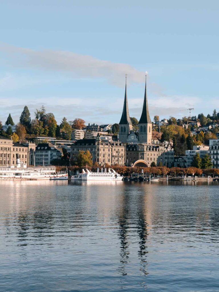 The cityscape of Lucerne with its iconic spires, as seen from a lake cruise on Lake Lucerne, a peaceful activity featured on lists of things to do in Lucerne