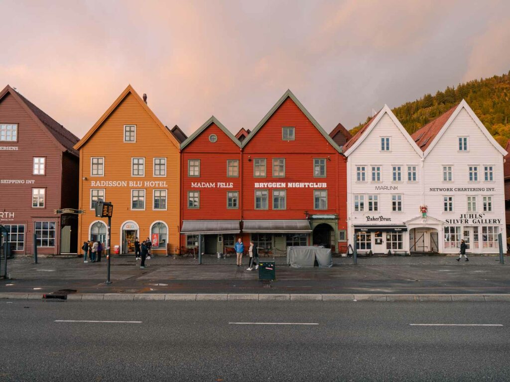 The iconic colorful façades of Bergen's Bryggen at sunset, with their historic charm casting a warm glow, a must-visit landmark on a two-week Norway journey