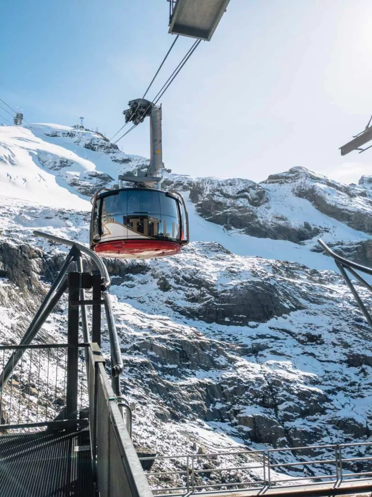 The Titlis cable car glides over a rugged, snow-covered landscape, an experience that rivals the scenic journeys up Stanserhorn, Pilatus or Rigi