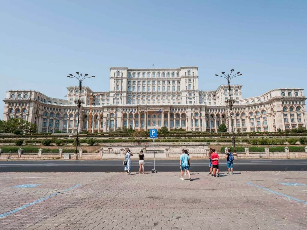The grand Palace of the Parliament in Bucharest, with tourists in the foreground, an essential stop for anyone’s Bucharest itinerary