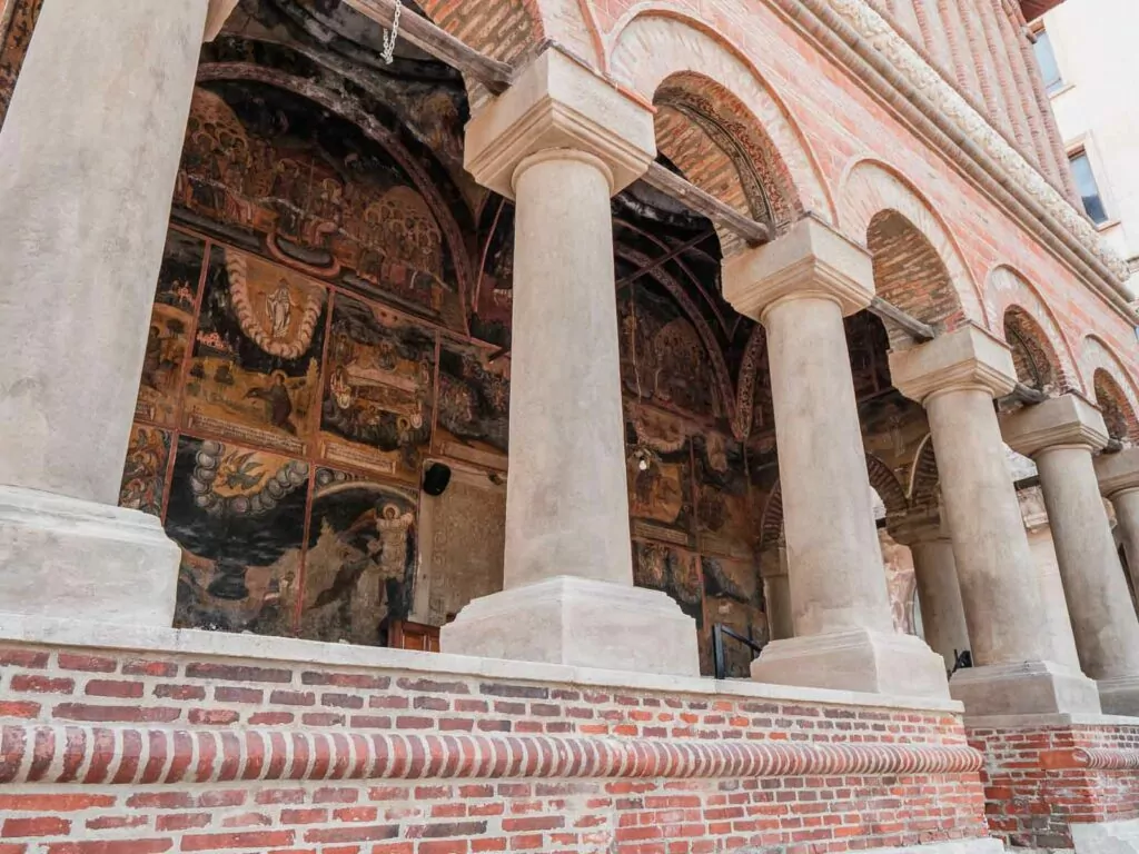 Stavropoleos Monastery church porch in Bucharest with its intricate frescoes and ornate columns, a must-see on a 2 days in Bucharest cultural tour