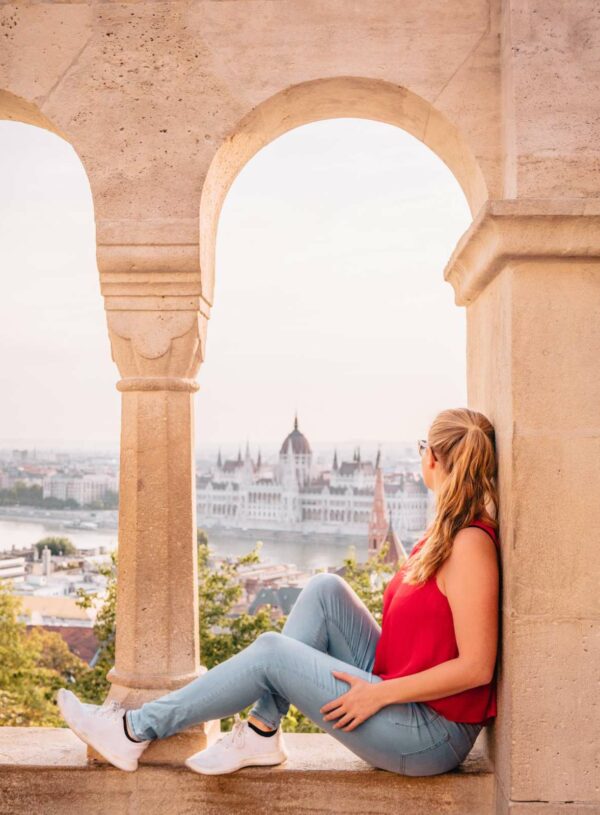 A serene view from Fisherman's Bastion in Budapest, Hungary, with a contemplative observer gazing out towards the Parliament building, an ideal start to a three months in europe journey.
