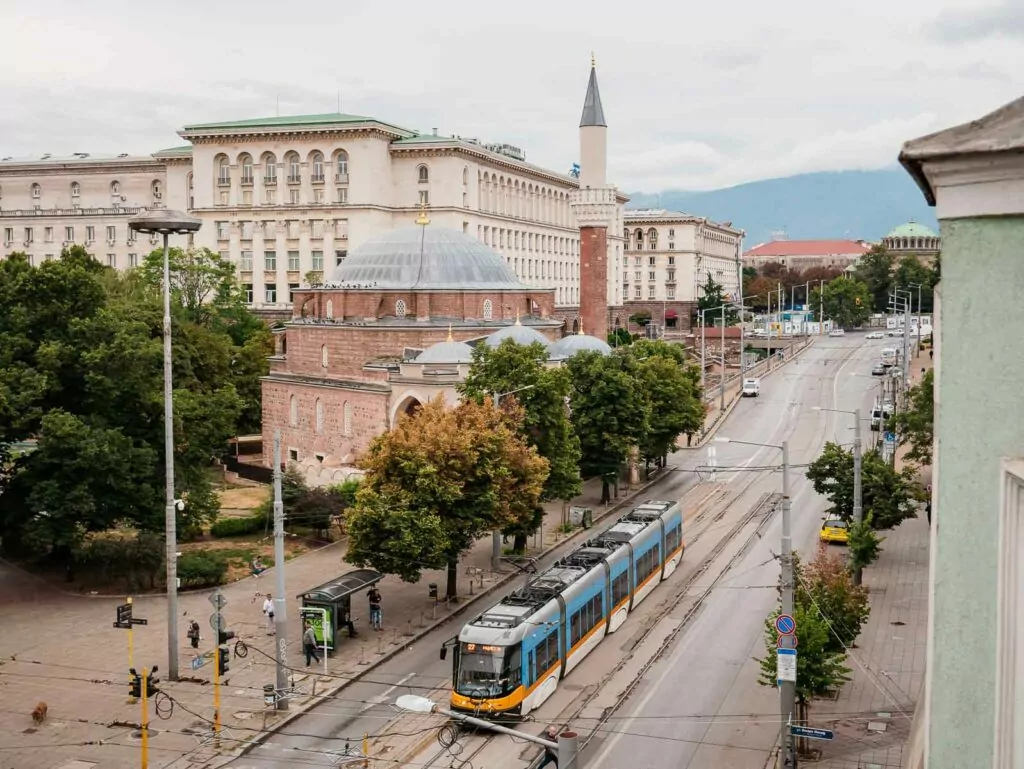 Overlooking a Sofia boulevard with a tram passing by, showcasing the everyday commute in the city, an image capturing the essence of a 1 day in Sofia itinerary
