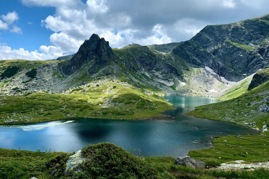 Tranquil mountain lake on the Seven Rila Lakes hike with verdant slopes in the Bulgarian countryside, a breathtaking natural wonder for those extending their Sofia itinerary