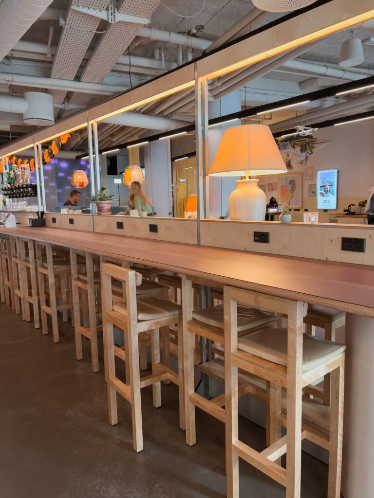 A communal dining area with stylish bar stools and warm lighting, inviting solo travellers in Copenhagen to work, socialise and dine