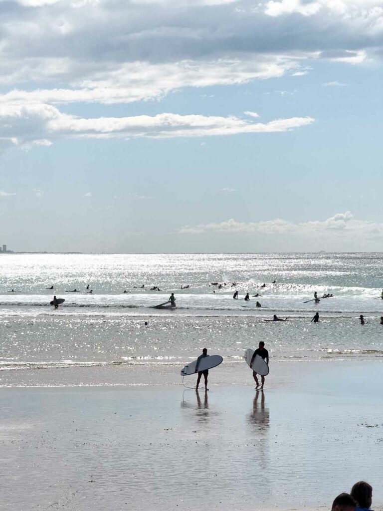 Surfers entering the waves at a Gold Coast beach