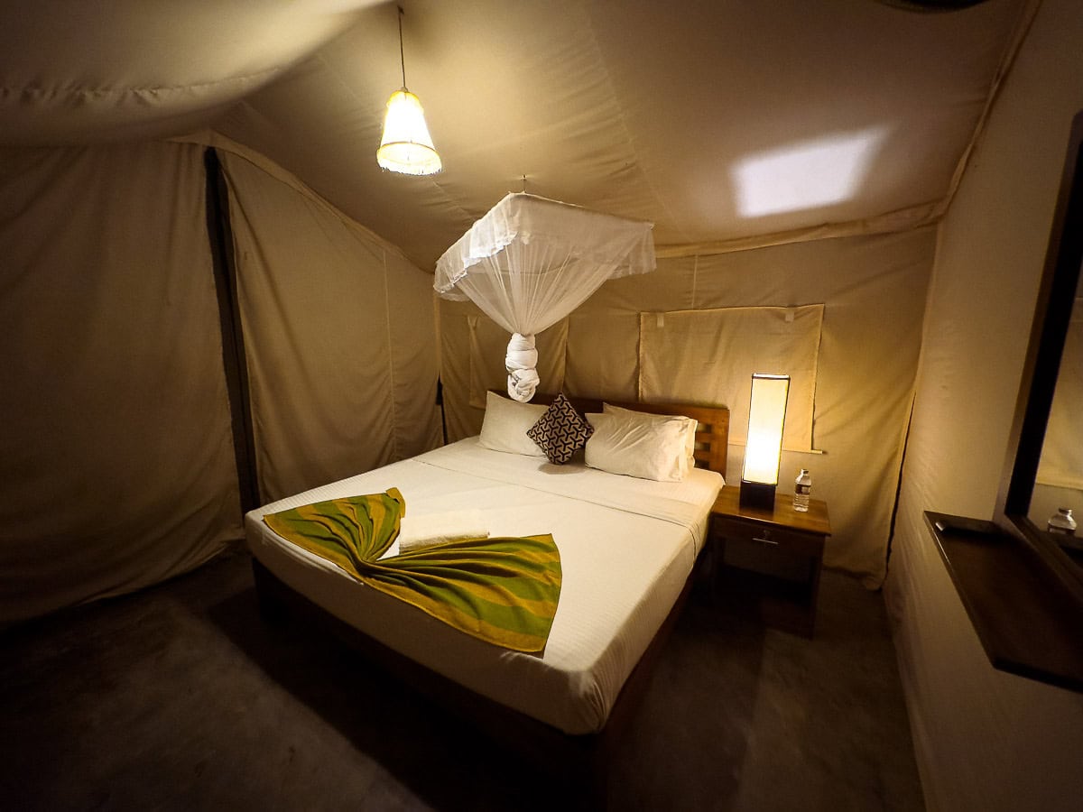 Glamping tent with a double bed and mosquito net at a One Life Adventures stay in Sri Lanka
