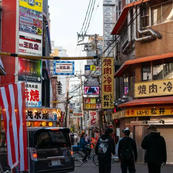 Busy street in Japan lined with shops and signs in Japanese.