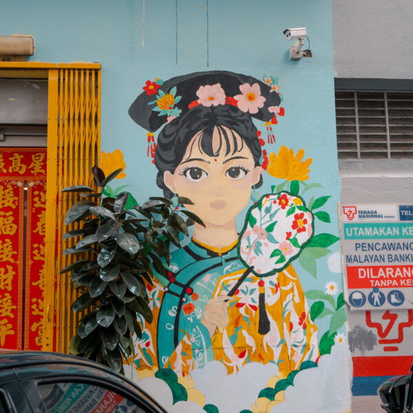 A charming mural of a woman in traditional dress on a street in Kuala Lumpur, adding to the city’s cultural appeal