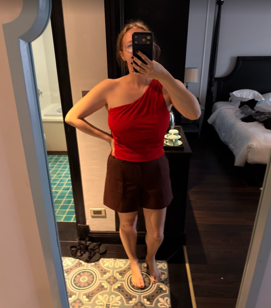 Red one shoulder top and chocolate brown shorts, both from Pink Lotus tailor in Hoi An, mirror shot