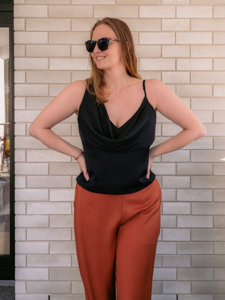 Black cowl neck top from Pink Lotus tailor in Hoi An, worn with rust trousers