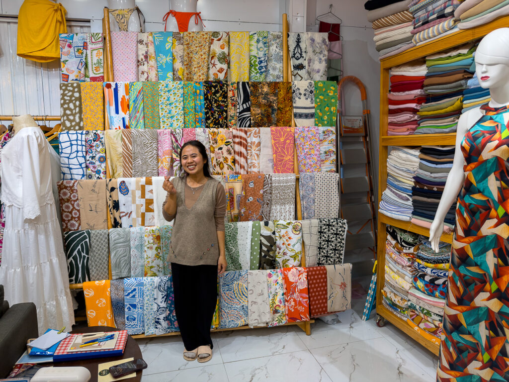 Tram at MyAn Soul tailor in Hoi An, by the wall of patterned fabrics