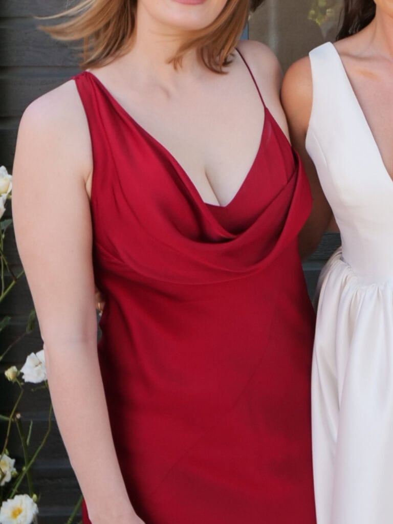 Alexx wearing a deep red satin cowl neck dress, the style used as a copy reference