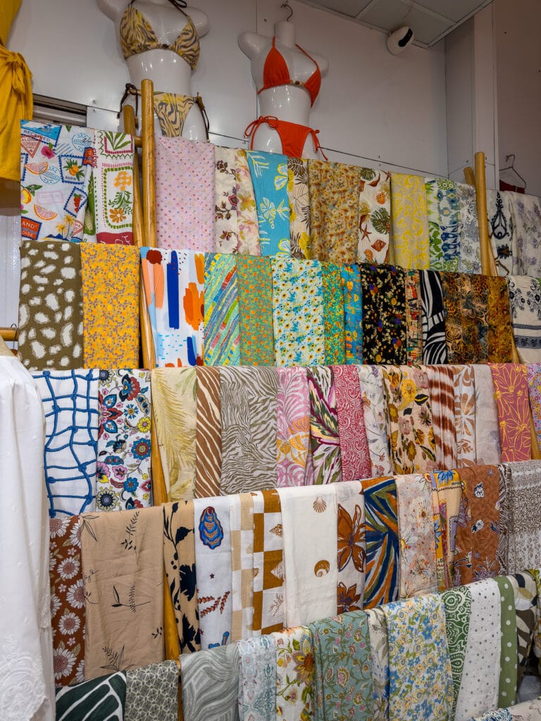 Wall of colourful patterned fabric swatches at Myan Soul tailor in Hoi An