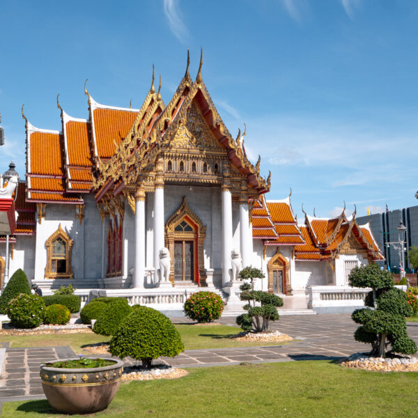 The stunning Wat Benchamabophit, or Marble Temple, with a red and gold roof and manicured gardens, a must-see on any Bangkok itinerary.