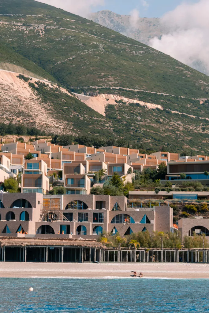 A luxury hotel complex in Dhermi built into the mountainside demonstrates upmarket tourism development in Albania