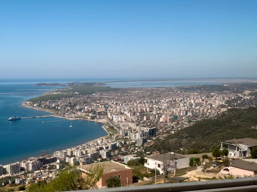 An aerial view over Vlore shows the curved bay and densely packed buildings climbing the hillside