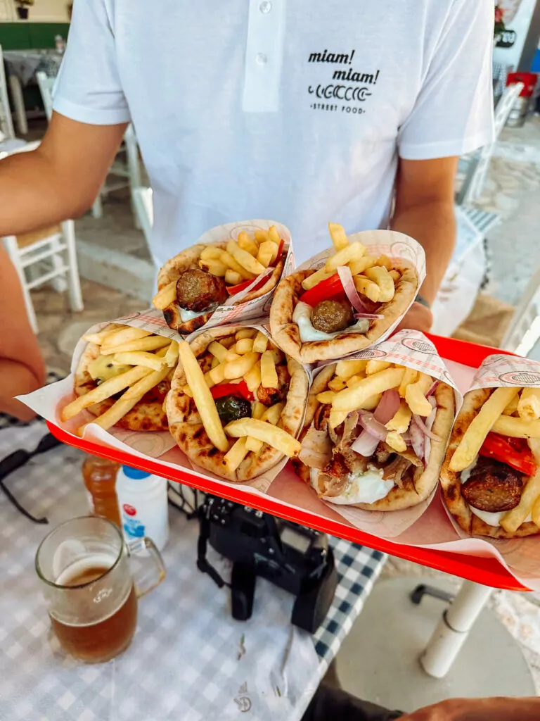 A tray of freshly made gyros, loaded with fries, meat, and vegetables, served at a casual Greek eatery while greek island hopping