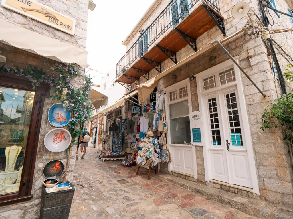 A charming cobblestone street in Symi, Greece, lined with traditional buildings, boutique shops, and colourful decorations